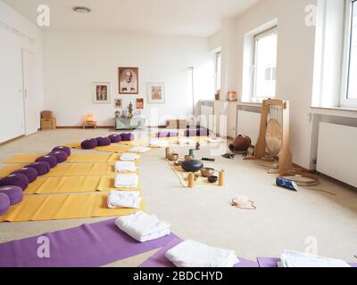 Strumento allestito con tappetini e cuscini per lo yoga e coperta per una sessione di guarigione con terapia di guarigione del suono. Foto Stock