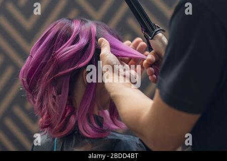 Il parrucchiere fa la donna di hairstyle i capelli vividly colorati Foto Stock