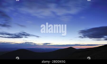 Cielo incredibile prima dell'alba nei Carpazi, silhouette di montagne all'orizzonte Foto Stock