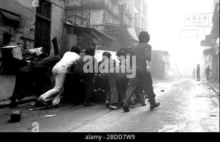 I servizi di emergenza, tra cui gli equipaggi antincendio, assistono a un incendio in Kennedy Street, della Queen's Road East sull'isola di Hong Kong nel 1979, mentre un team di lavoratori in tute cerca di far saltare un'auto alla sicurezza. Foto di Tony Henshaw Foto Stock