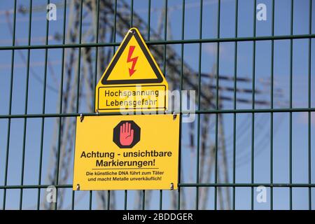 22.03.2020, Nunsdorf, Brandeburgo, Germania - segni - DNA artificiale - e - pericolo di alta tensione per la vita - sulla recinzione di una stazione di trasformazione. 00S20 Foto Stock