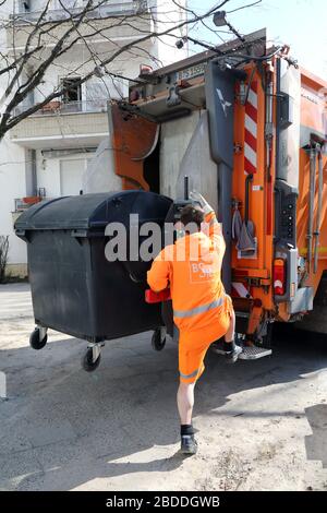24.03.2020, Berlino, , Germania - il dipendente della BSR controlla lo svuotamento di un bidone dei rifiuti residui pieno. 00S200324D259CAROEX.JPG [VERSIONE DEL MODELLO: NO, PROPERTT Foto Stock