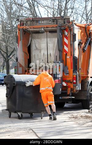 24.03.2020, Berlino, Berlino, Germania - i dipendenti della BSR spingono un cestino dei rifiuti pieno verso il camion dei rifiuti per lo svuotamento. 00S200324D250CAROEX.JPG [MOD Foto Stock