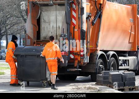 24.03.2020, Berlino, Berlino, Germania - i dipendenti della BSR spingono un cestino dei rifiuti pieno verso il camion dei rifiuti per lo svuotamento. 00S200324D247CAROEX.JPG [MODELLO RE Foto Stock
