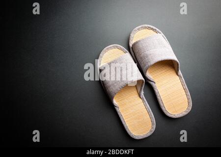 Comode pantofole di casa su sfondo nero. Morbida e confortevole. Concetti di soggiorno a casa. Foto Stock