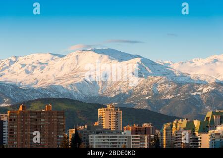 Skyline degli edifici residenziali del quartiere Las Condes con la catena montuosa Los Andes innevata sul retro, Santiago del Cile, Sud America Foto Stock