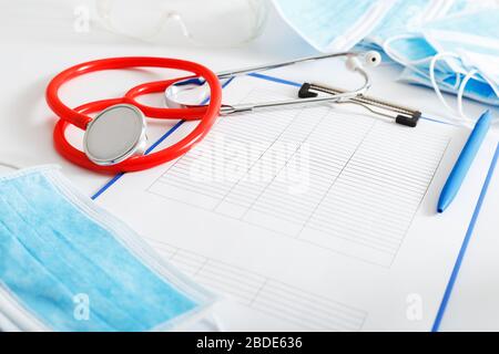 Nomina del medico. Stetoscopio rosso, maschere igieniche mediche, documenti medici sul posto di lavoro dei medici in clinica. Medicina di concetto sanità, ricerca Foto Stock