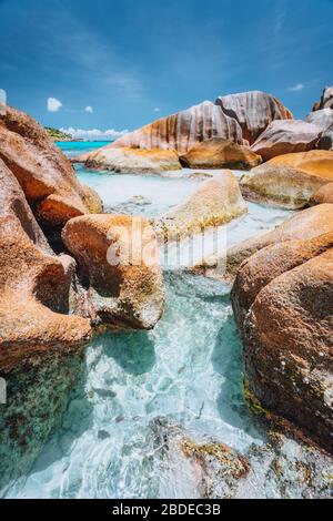 Rocce bizzarre a forma di acqua blu oceano sulla spiaggia di Anse Cocos, l'isola di la Digue, Seychelles Foto Stock