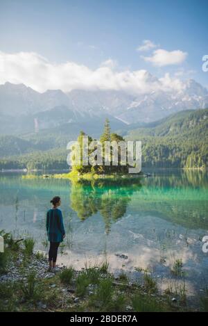 Germania, Baviera, Eibsee, giovane donna in piedi sulla riva del lago ofÂ EibseeÂ nelle Alpi Bavaresi Foto Stock