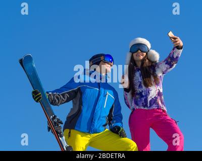 Coppia amorevole che fa selfie di inverno su una cima di montagna. Stazione sciistica. Sport, concetto di vita sano e attivo. Foto Stock