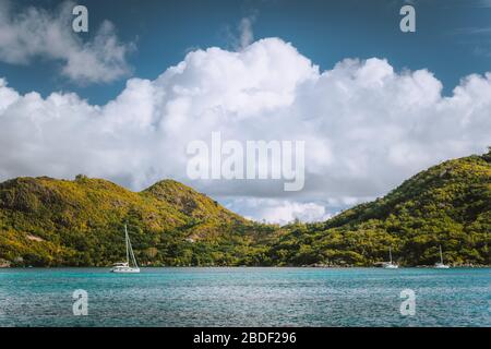 Barche a vela vicino ad un'isola inabitabile vicino a Victoria City, Mahe, Seychelles Foto Stock