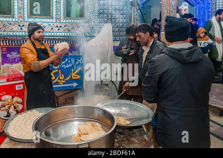 L'uomo usa la farina di grano intero, l'impasto dei poori è fatto in palle piccole, arrotolato in disco e fritto liberato, Jhelum, Punjab, Pakistan Foto Stock