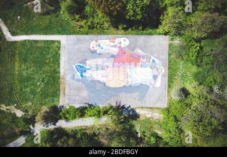 Immagine drone di parco giochi dipinta in coppia sdraiata sulla schiena e guardando il cielo Foto Stock