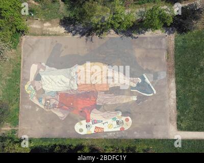 Immagine drone di parco giochi dipinta in coppia sdraiata sulla schiena e guardando il cielo Foto Stock