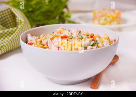 Insalata tradizionale russa Olivier con verdure e carne nella ciotola bianca Foto Stock