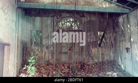 Vecchia e arrugginita casa abbandonata creepy dalla porta di fronte Foto Stock