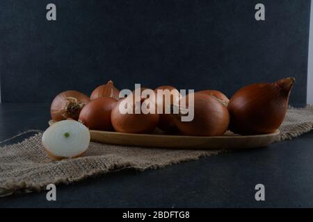 Un gruppo di cipolle su sfondo scuro Foto Stock