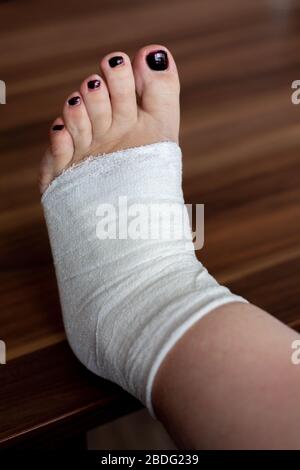 Femmina sta avvolgendo la sua ferita del piede con bendaggio Foto Stock