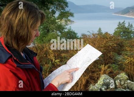 Donna che legge una mappa di indagine di Ordance su una passeggiata intorno Haweswater nel distretto inglese del lago, Cumbria, Regno Unito. Foto Stock