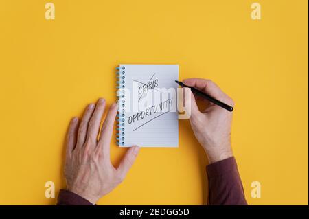 Le mani maschili che attraversano la crisi di parola e l'occasione di parola di scrittura in un'immagine concettuale della determinazione e dell'azione personali. Foto Stock
