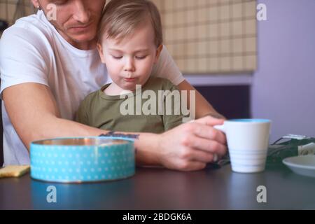 Padre e figlio sono seduti in cucina bevendo il tè Foto Stock