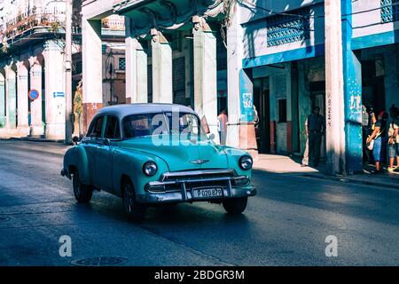 HAVANA, CUBA - 10 DICEMBRE 2019: Havana Cuba Classic Cars. Typcal Havana scena urbana con edifici colorati e vecchie auto. Foto Stock