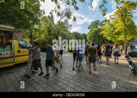 Como, ITALIA - 4 agosto 2019: La gente del posto e i turisti sul lungomare del lago nel centro della bellissima città italiana di Como. Caldo sole sumo Foto Stock