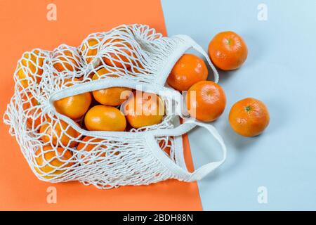 Gruppo di tangerini freschi nel sacco di cotone a corda isolato, piatto, vista dall'alto. Plastica libera, concetto ecologico zero rifiuti. Foto Stock