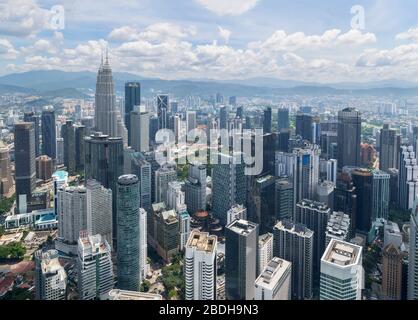 Vista sullo skyline del centro dalla KL Tower (Menara Kuala Lumpur) guardando verso le Petronas Twin Towers e il KLCC Park, Kuala Lumpur, Malesia Foto Stock