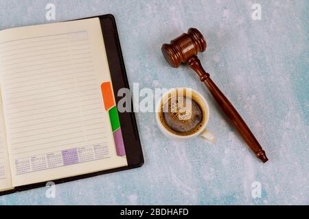 Spazio di lavoro con blocco note vuoto aperto Judge Law gavel su una tazza di caffè espresso Foto Stock