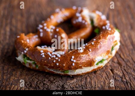 Pretzel bavarese con burro su legno Foto Stock