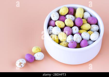 Mini uova di Pasqua colorate in una ciotola bianca Foto Stock
