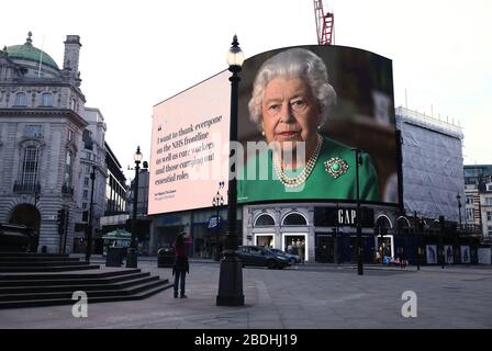 Un'immagine della Regina Elisabetta II e citazioni dalla sua trasmissione Domenica al Regno Unito e il Commonwealth in relazione all'epidemia di coronavirus sono esposti sulle luci nel Piccadilly Circus di Londra. Foto Stock