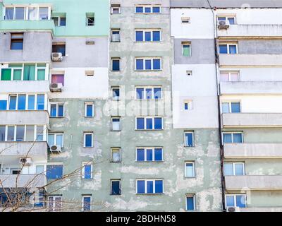 Facciata di un vecchio edificio residenziale a più piani con vernice verde. L'edificio ha bisogno almeno di essere ristrutturato. Povertà. Vista frontale. Foto Stock