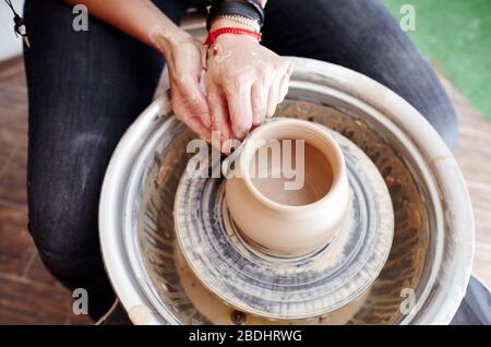 Mani di donna che stampano argilla. Vasaio che fa vaso di ceramica in laboratorio di ceramica Foto Stock