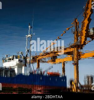 Costruzione di navi e gru in acqua ferma. Foto Stock