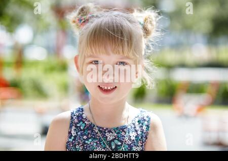 Adorabile bambino in abito posa all'aperto. La giovane caucasica gode di un'estate o di uno stile di vita primaverile Foto Stock