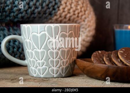 Primo piano di una tazza di caffè, biscotti e coperta, rustica Foto Stock