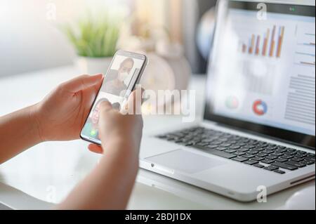 Utilizzo dello smartphone conversazione virtuale con amici, colleghi e videoconferenza con chat. Gruppo di persone che lavorano in modo intelligente da casa. Home quaranti Foto Stock