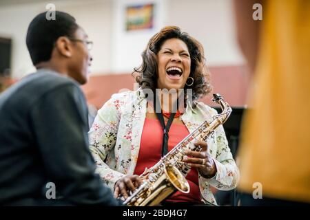 Insegnante di musica e studente di scuola superiore divertirsi durante una lezione Foto Stock