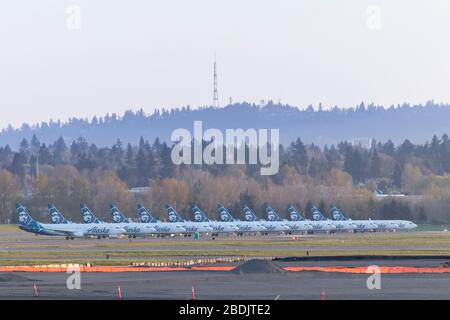 PORTLAND, OR / USA - Aprile 7 2020: Aerei Alaska Airlines a terra in terra all'Aeroporto Internazionale di Portland a causa della pandemia di coronavirus e signi Foto Stock