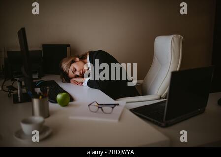 Stanco giovane bionda uomo d'affari caucasico che dorme in ufficio Foto Stock