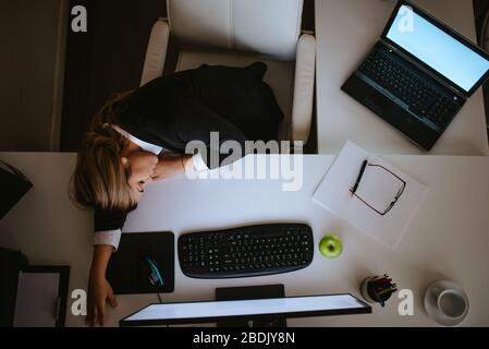 Stanco giovane bionda uomo d'affari caucasico che dorme in ufficio Foto Stock