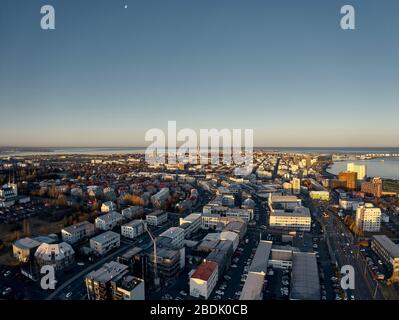 Dall'alto del tranquillo e moderno quartiere costiero della città, con una bassa architettura alla luce del sole mattutina in Islanda Foto Stock