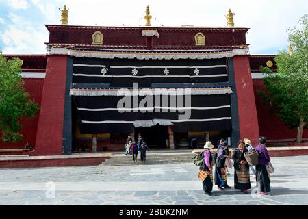 I locali si riuniscono di fronte alla Sala di Cuoqin nel Monastero di Pelkor Chode a Gyantse, la regione autonoma del Tibet. Foto Stock