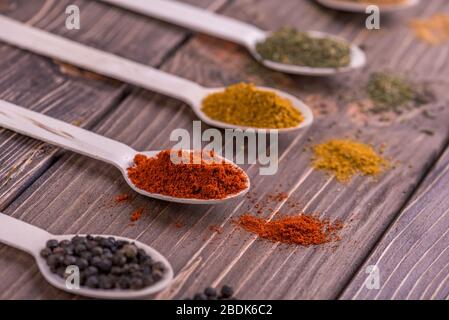 Assortimento di spezie colorate in i cucchiai di legno. Foto Stock