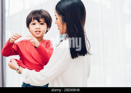 Asian felice madre bella ottenere vestiti vestiti sui suoi capretti per andare a scuola Foto Stock