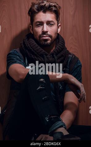 Un uomo con la barba in abiti casual siede Foto Stock