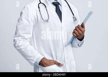 Corto di terapista nero che tiene carta medica Foto Stock