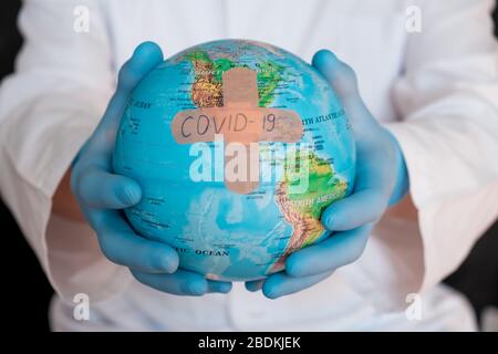 Globo mondiale con maschera medica verde su di esso. Concetto di epidemia di coronavirus. Concetto per la diffusione mondiale della disperazione di Coronavirus.. Foto Stock